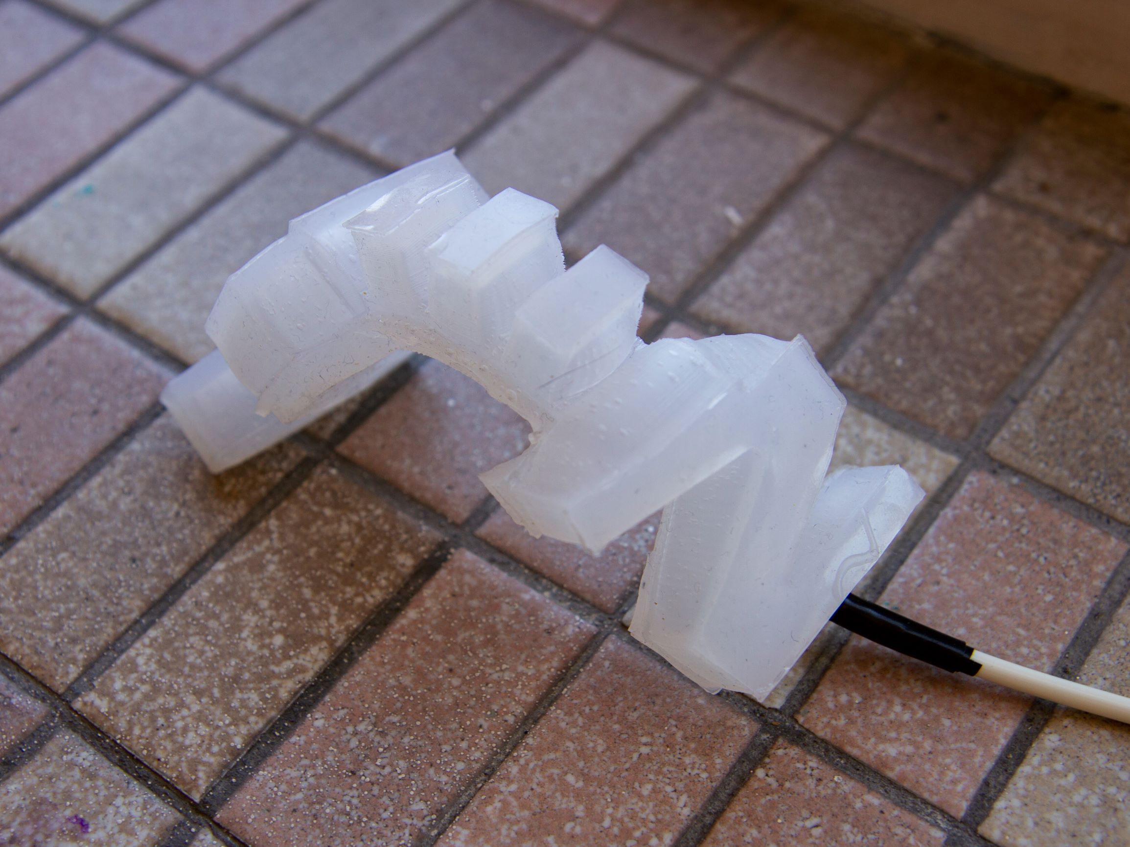 <b>Pneumatic Silicone Actuator</b><p><em>I 3D printed 3-part molds to make several iterations of the actuator.
           The one that worked the best is a composite of two different designs, one that curled and one that grew in length
           when inflated.</em></p>